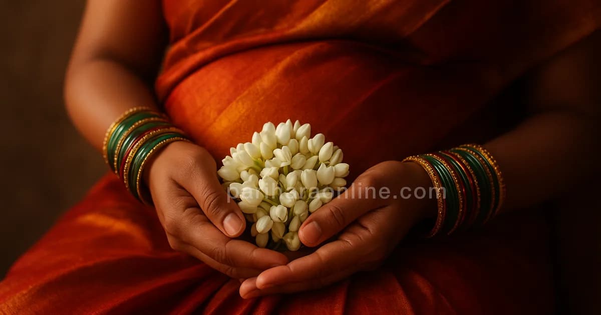 A pregnant woman's hands with green and red glass bangles holding jasmine over silk — seemantham and valaikappu | pariharaonline.com